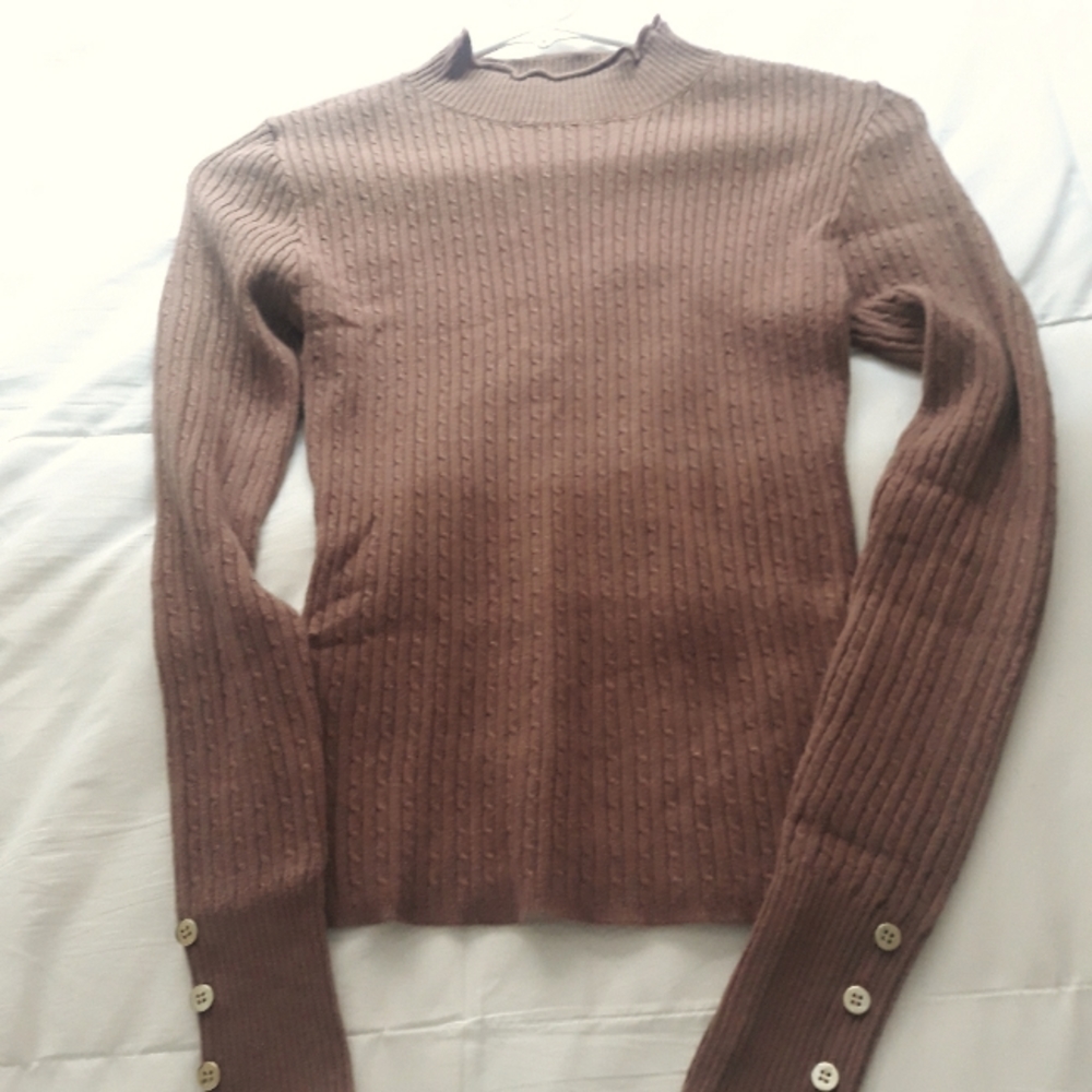 Sweater blouse with small gold buttons.